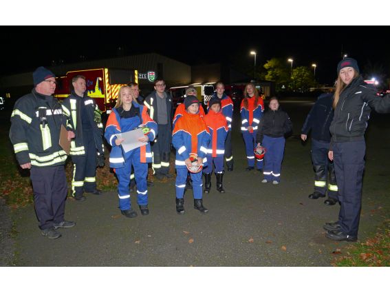 Die Jugendfeuerwehrleute müssen den Wassereimer aus dem Schlauchkreis bewegen, ohne mit den Füßen den Boden zu berühren.